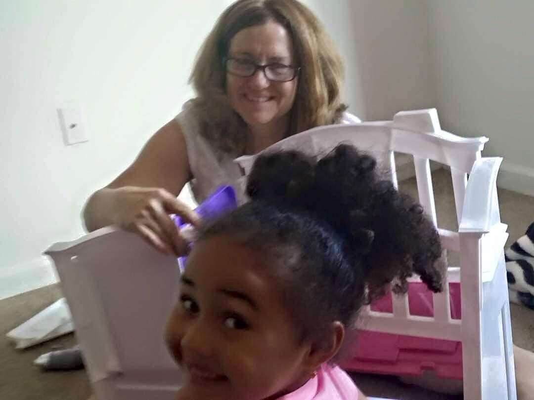 Grandm* and Kamille putting together a doll nursery.