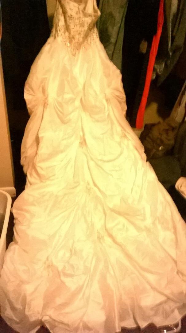 It's white in color. Custom sized roughly a size 20 and its way to long for me even in heels and I'm 5'3. Strapless wedding gown. Pictures don't do it justice asking $300 obo