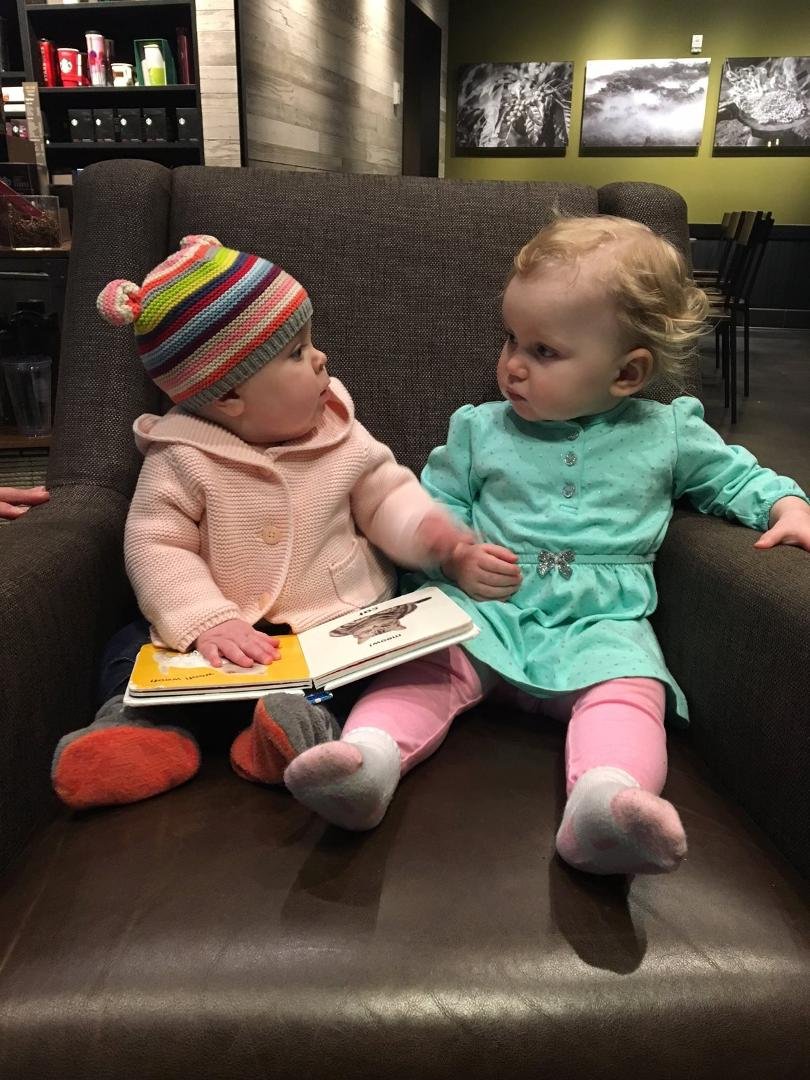 Our grandaughter Sophie (on left) explaining a book to a new friend at the library. 😇