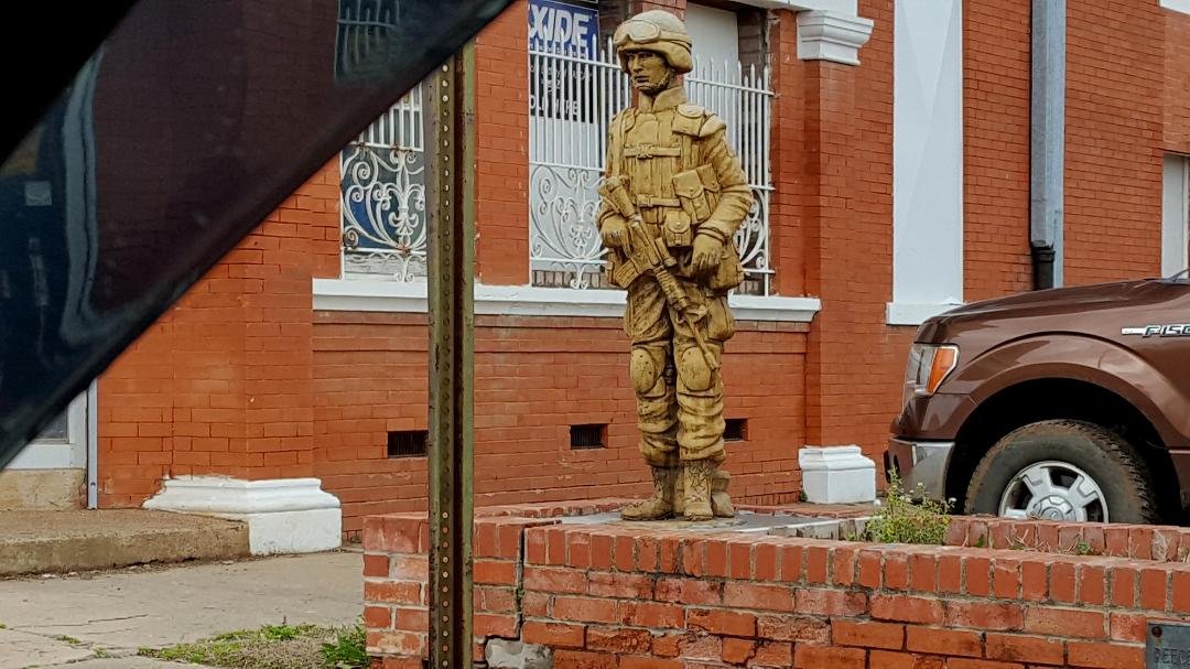 Commemorative soldier in front of store in Blossom, Texas