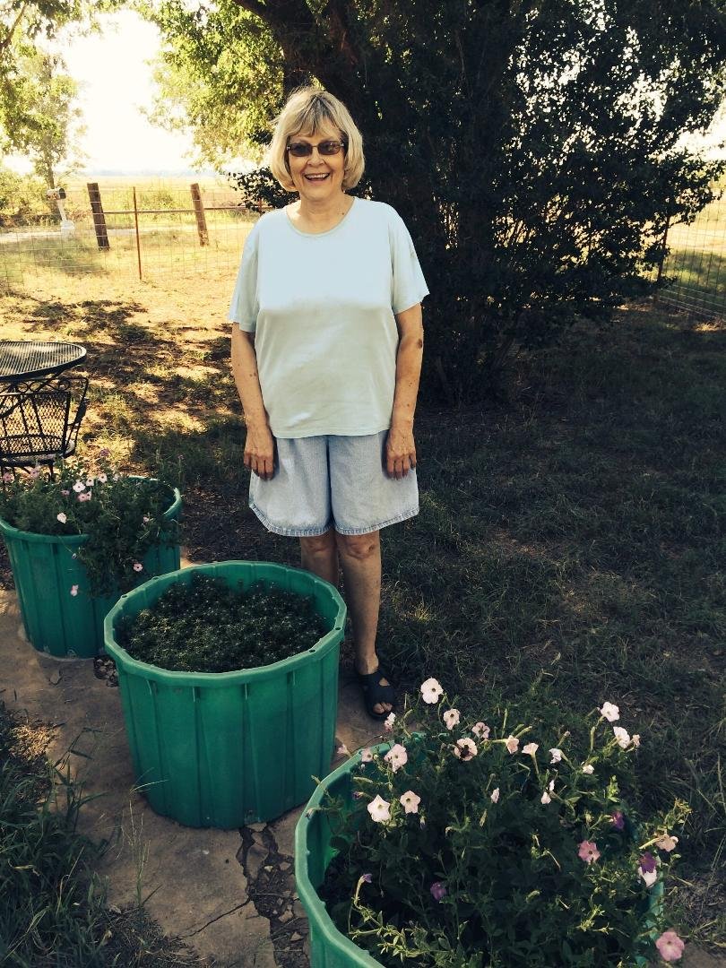 Phyllis at the Bennett home place. These flowers are from her Grandmother - at least 100yrs. old!
