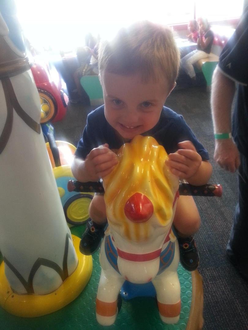 Alex, my younger nephew, riding a ride at Chuck E. Cheese