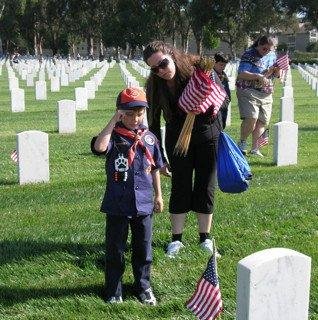 Boy Scout lays flag Los Angeles National Cemetery.