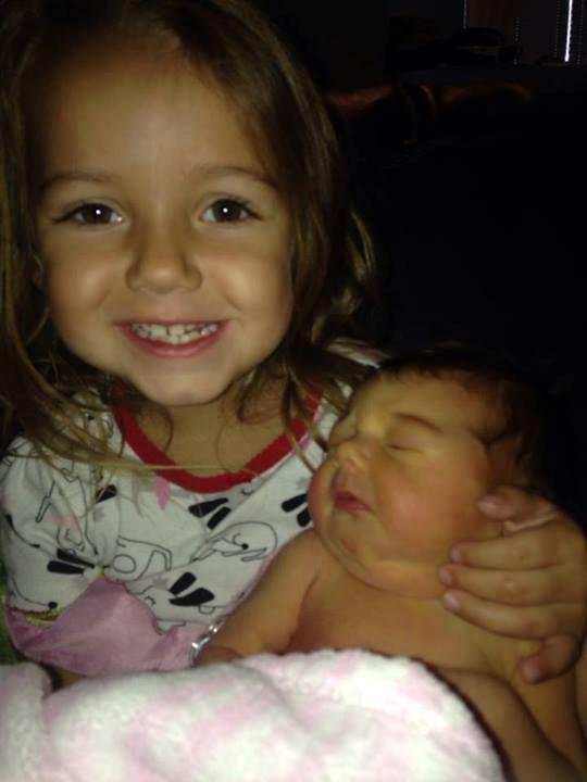 Addy is holding her new baby sister Kenna.