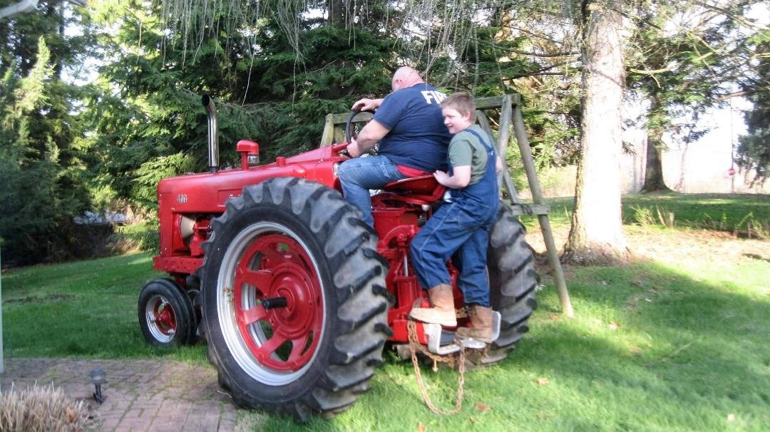 Arthur and his dad on the farmall