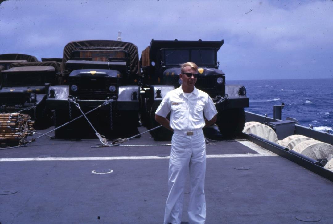 On board USS Ogden, 1966 on way to Vietnam. Flight deck loaded with trucks, tanks and jeeps and who knows what else. On way back we were loaded with damaged-wrecked vehicles.