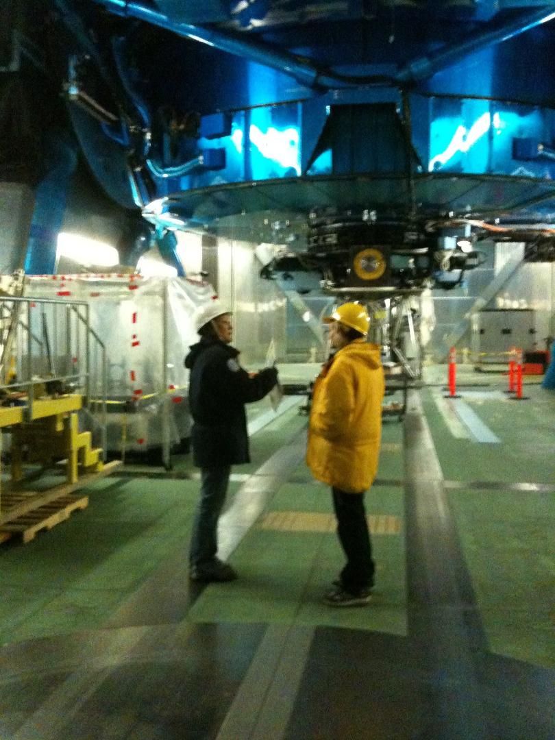 Guide Reiko explaining the Subaru telescope to Coleen during our observatory tour.