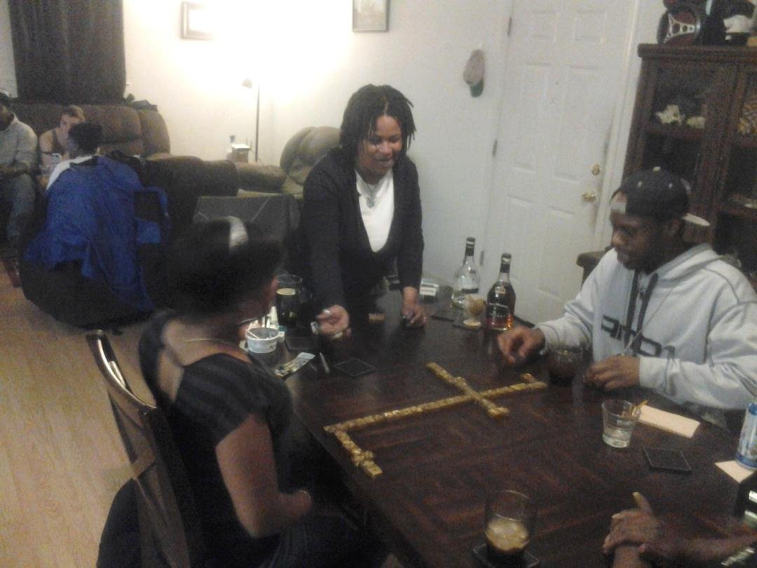 the birthday girl playing dominos with fam.