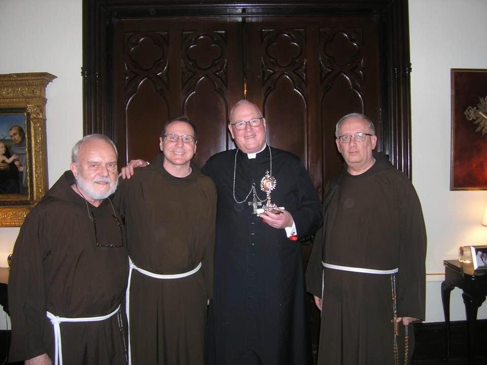 Capuchin friars presenting a relic of Bl Solanus Casey to Cardinal Dolan
