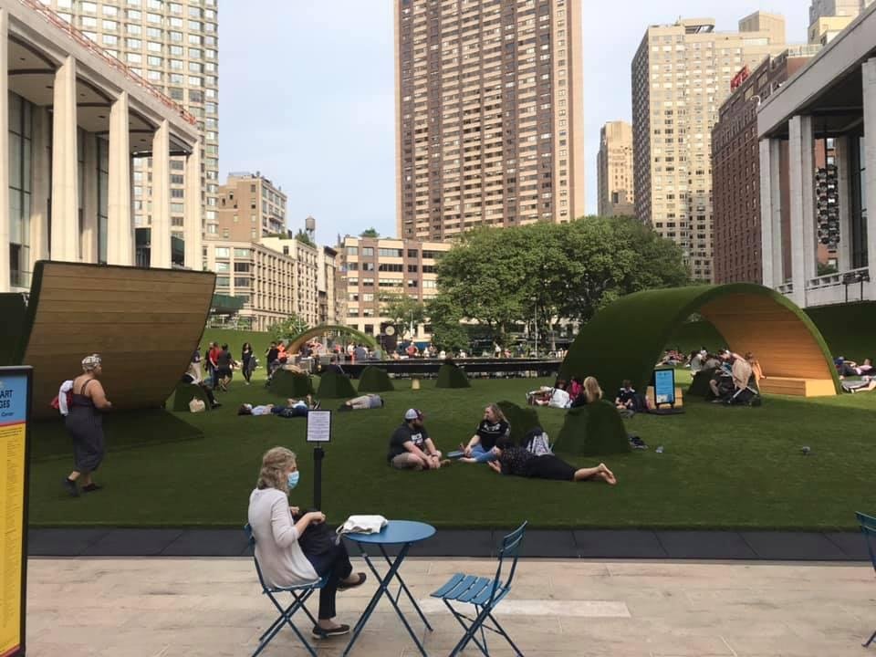Standing in front of the Met looking at the transformed plaza of Lincoln Center. The “turf” is soft and condusive to naps and rolling around (lol) which folks are doing!