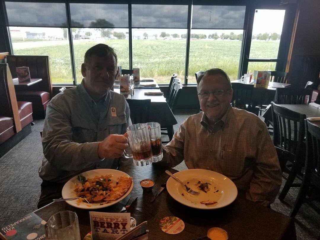 Silhouettes of Marv Kieckhafer and Dan toasting with an age appropriate beverage (diet coke).