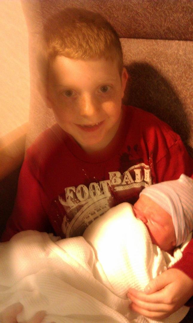 Ian is holding his new brother and is very tender!