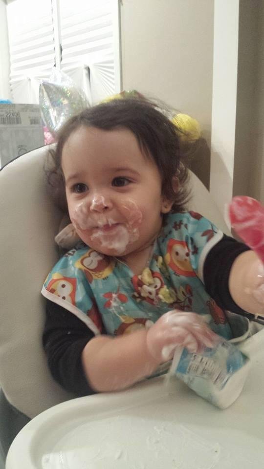 Loving my yogurt. Mommy let me hold it. YUMMY
