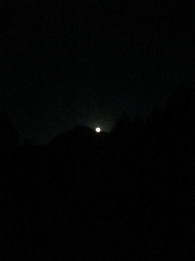 “The Special Giant Moon” over a dirt parking lot or a button over the same parking lot.
