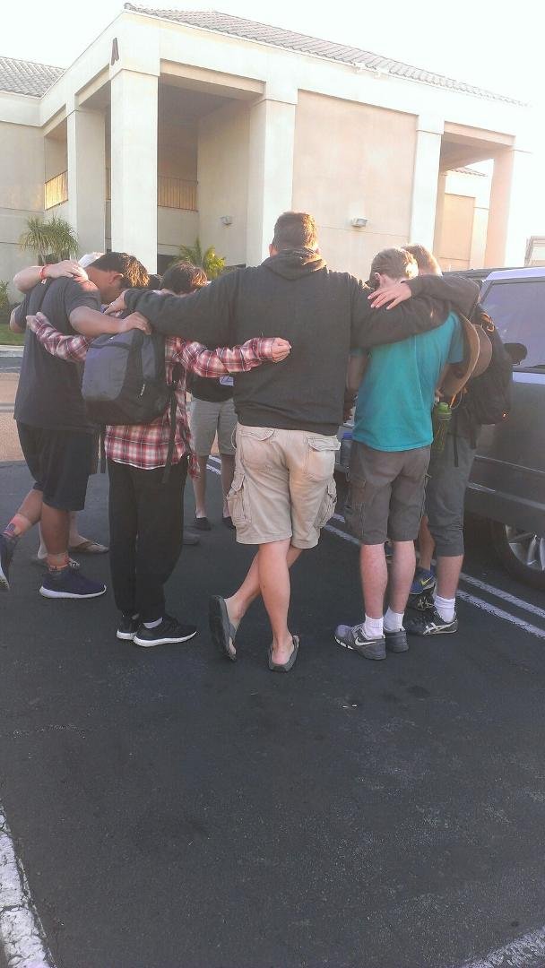 Taylor praying with Con team for safe journey home.