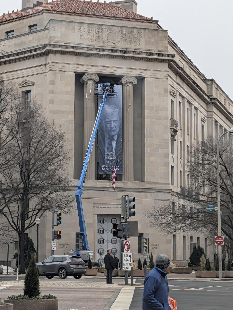 DOJ Putting a convicted Felon's picture up on their banner is peak irony. How is this what we're spending tax dollars on? Did we need a giant banner with his stupid face on it? Is that gonna do anything? Absolutely not. Thi