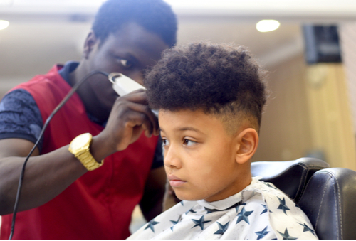Cute young boy getting a haircut at home