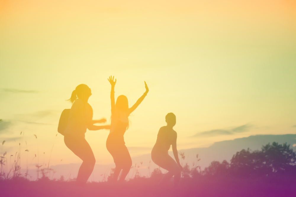 Silhouette of young women playing oustide in the sunset.