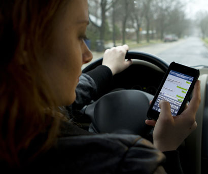 girl driving while using cell phone
