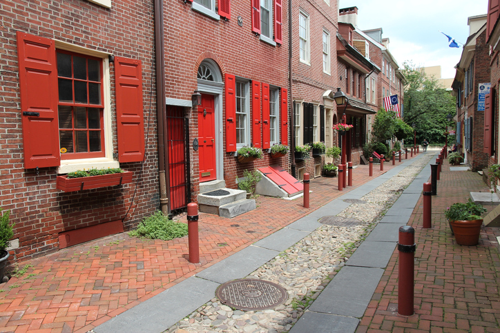 Philadelphia, United States - June 11, 2013: People visit Elfreth's Alley in Philadelphia. The alley is a National Historic Landmark. It dates back to 1702.