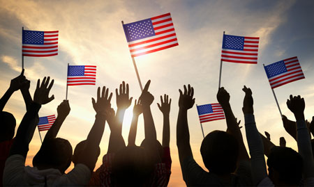 crowd holding up American flags