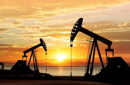 Image of oil and gas pumps at sunset.