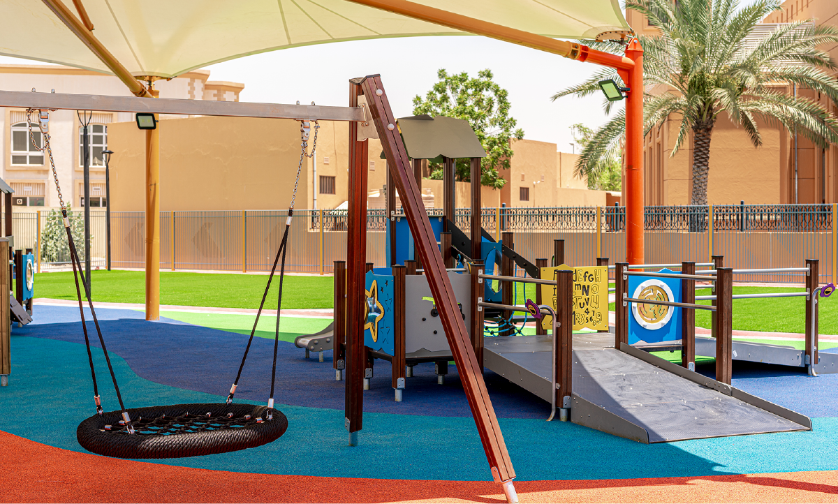 A picture of a playground with a basket swing and shapes on the playground.