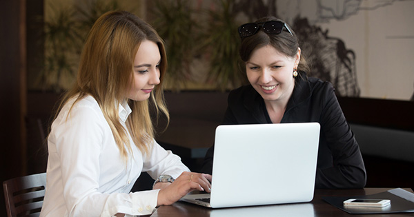 two people looking at a laptop