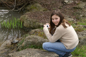 girl with camera by pond