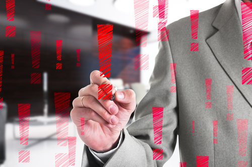 Businessman drawing a red exclamation mark.