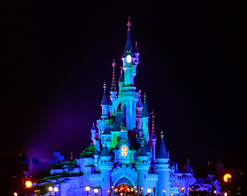 Paris, France - October 30, 2015: Sleeping Beauty Castle , the symbol of Disneyland Paris at night with a view of the main street.