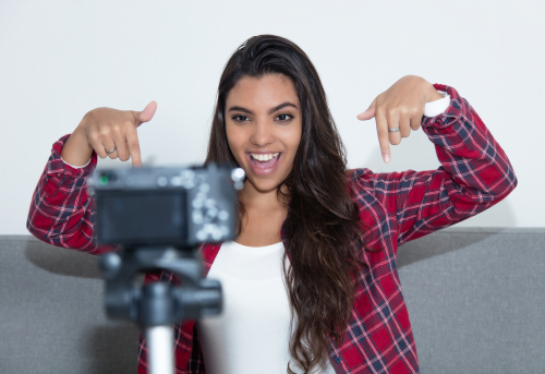girl recording video blog with camera at home