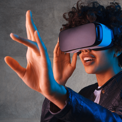 Amazed young woman touching the air during the VR experience. Horizontal studio shot.