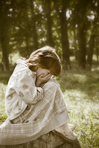 girl sitting on rock crying