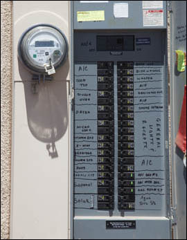 A photo of a circuit breaker box attached to the wall of a home.