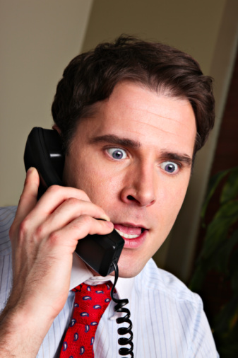 Businessman surprised on the phone.