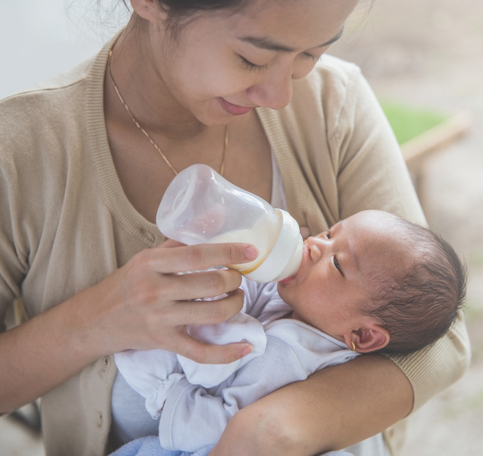Photo of woman feeding a baby