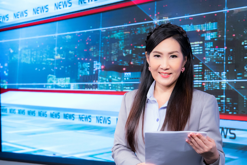 Asian television newscaster in a broadcast room