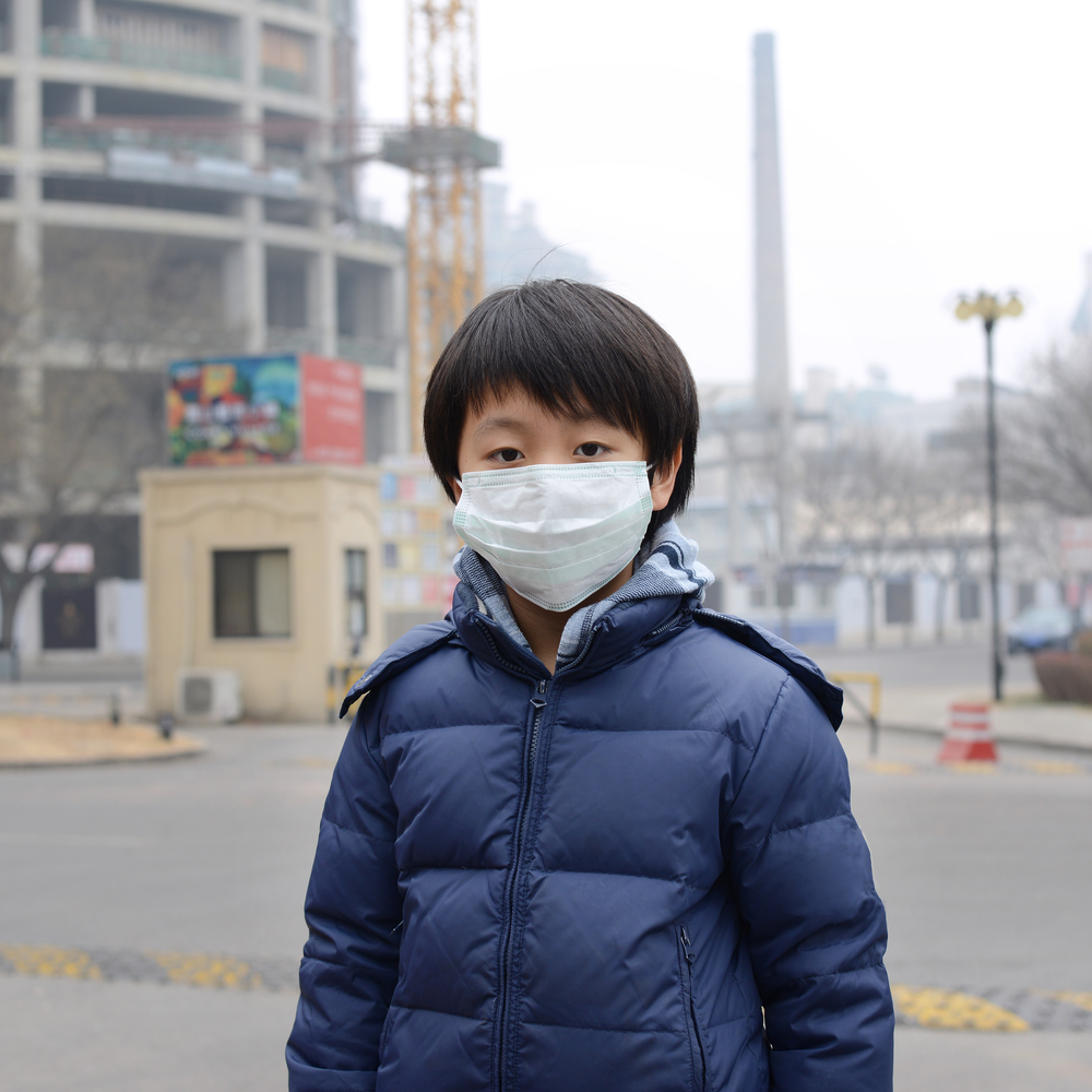 Child wearing mask to protect from polluted air
