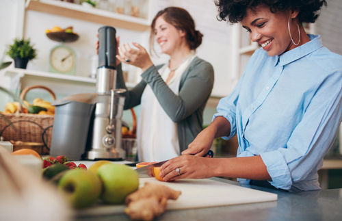 Young african woman cutting fruits at bar counter.