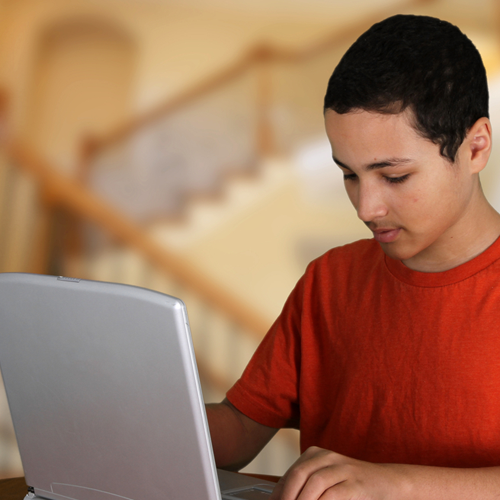 Teen boy doing homework after school at the table.