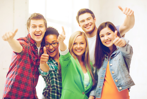 happy team of students showing thumbs up at school