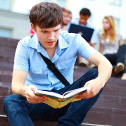 student sitting outside, reading