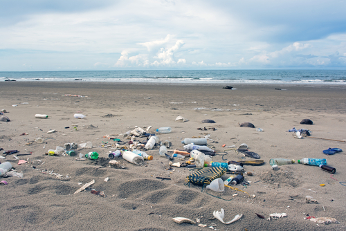 Trash scattered over a sandy beach.