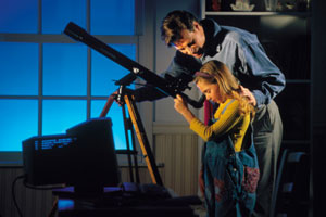 girl looking through telescope