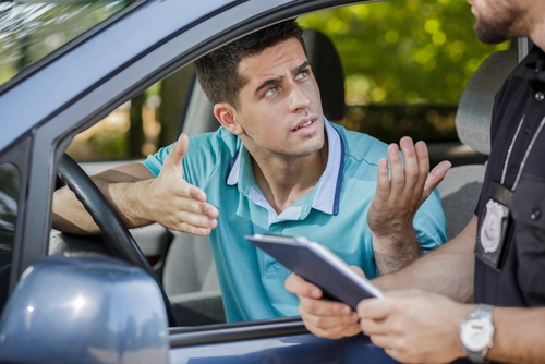 Shot of a young driver arguing with a traffic officer