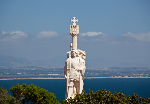 Skyline of San Diego in background behind statue of Cabrillo on Point Loma