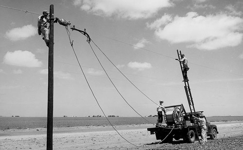 erecting telephone lines. This image is attributed to the National Archives and Records Administration