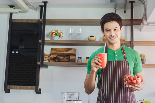 A young man serving juice drinks. Use enter key to open full-screen view.