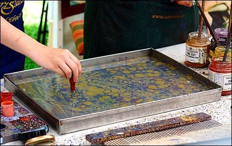 Oil-based inks in a tank of water being prepared for marbling.